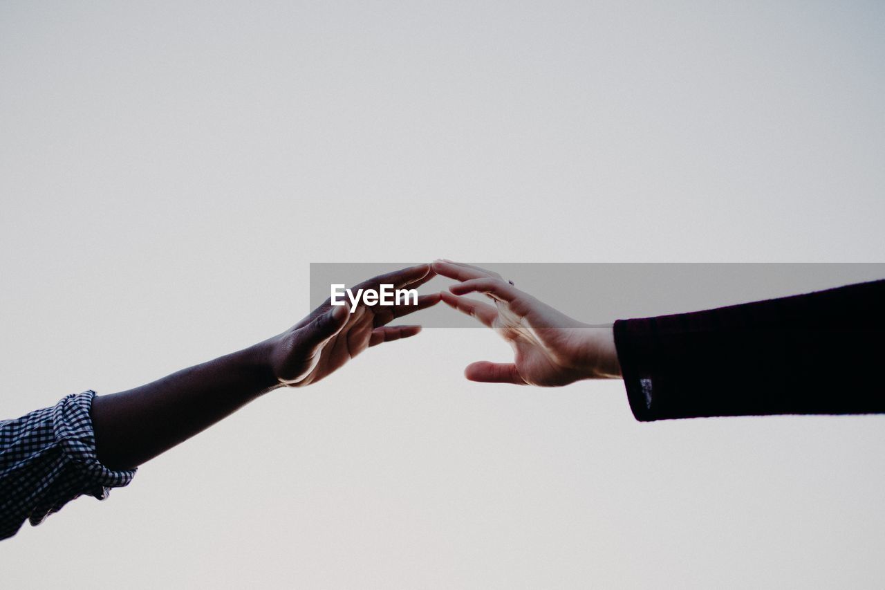 Close-up of couple reaching over white background