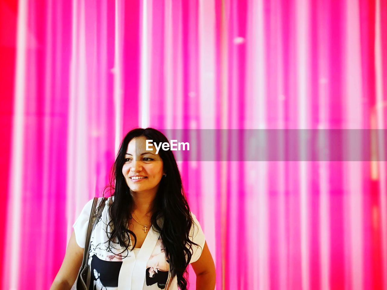 one person, smiling, happiness, women, adult, pink, portrait, young adult, front view, curtain, long hair, hairstyle, indoors, arts culture and entertainment, emotion, cheerful, enjoyment, standing, stage, looking at camera, copy space, waist up, lifestyles, music, singing, brown hair, person, fashion, event, black hair, casual clothing, clothing, teeth, red