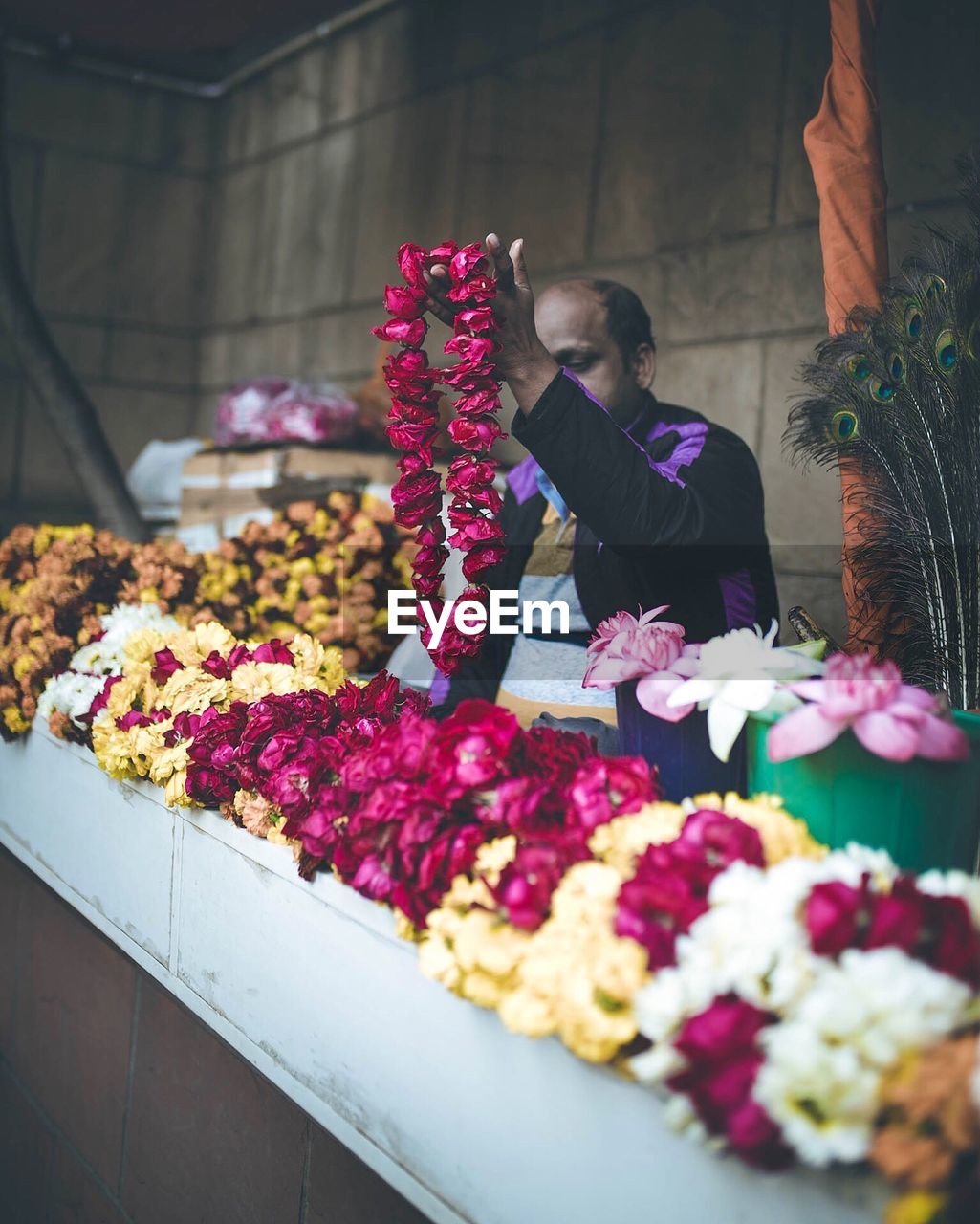 Vendor selling floral garlands at shop
