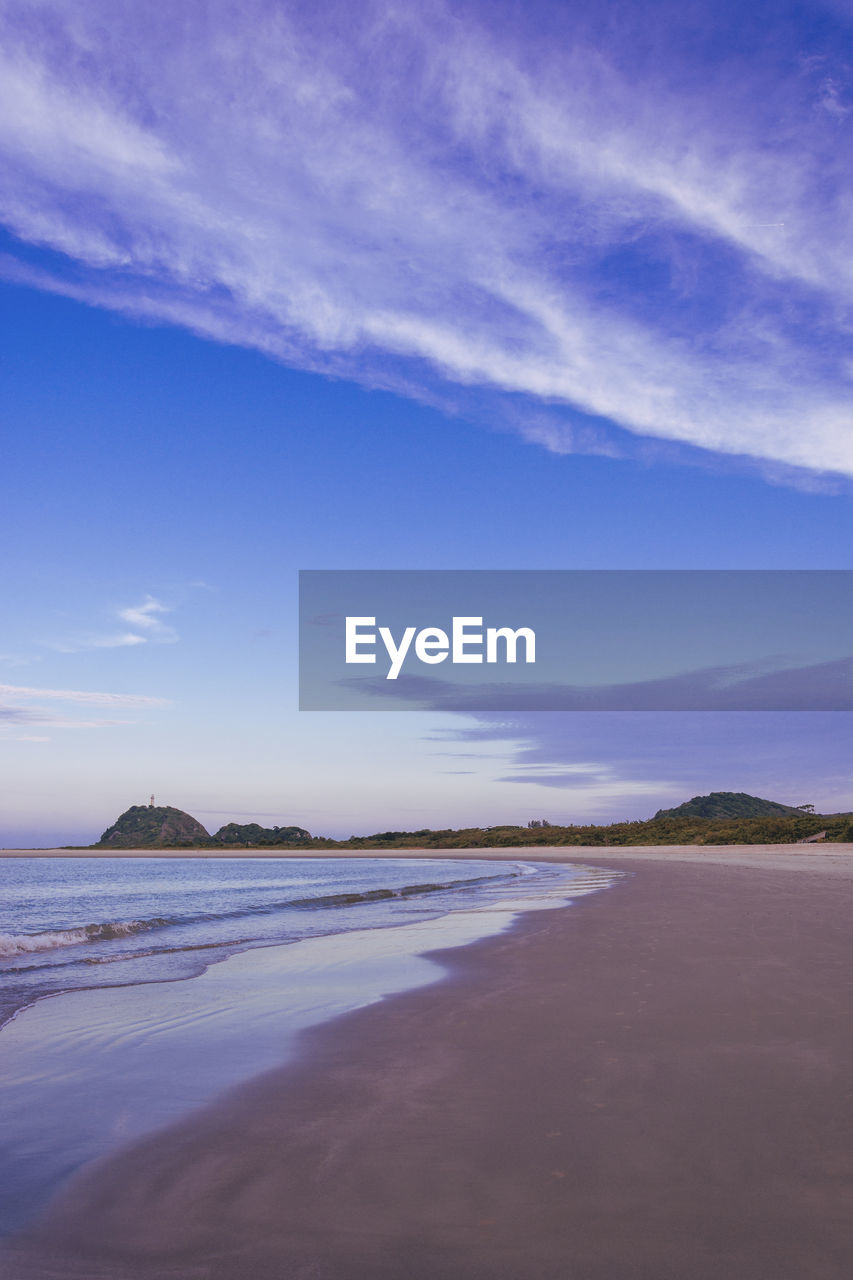 Scenic view of beach against blue sky