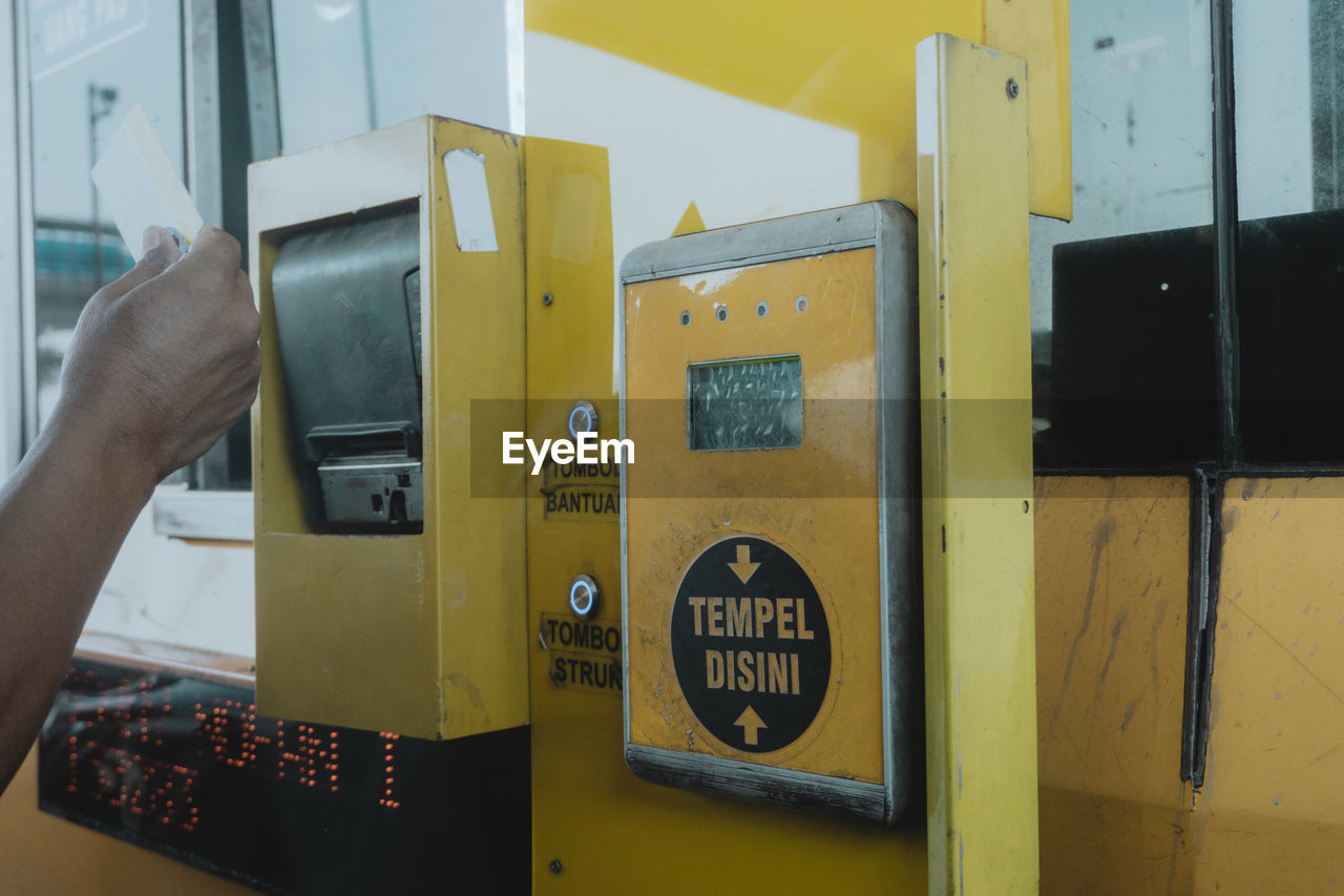 CLOSE-UP OF HAND ON YELLOW COMPUTER