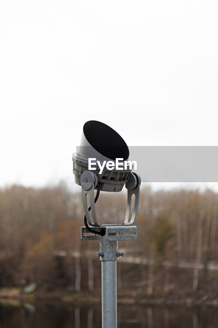 Modern headlight seen from the side with trees in the background