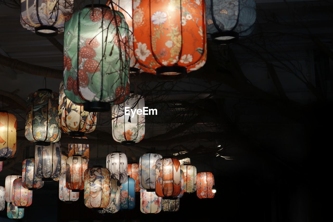 LOW ANGLE VIEW OF LANTERNS HANGING IN DARK