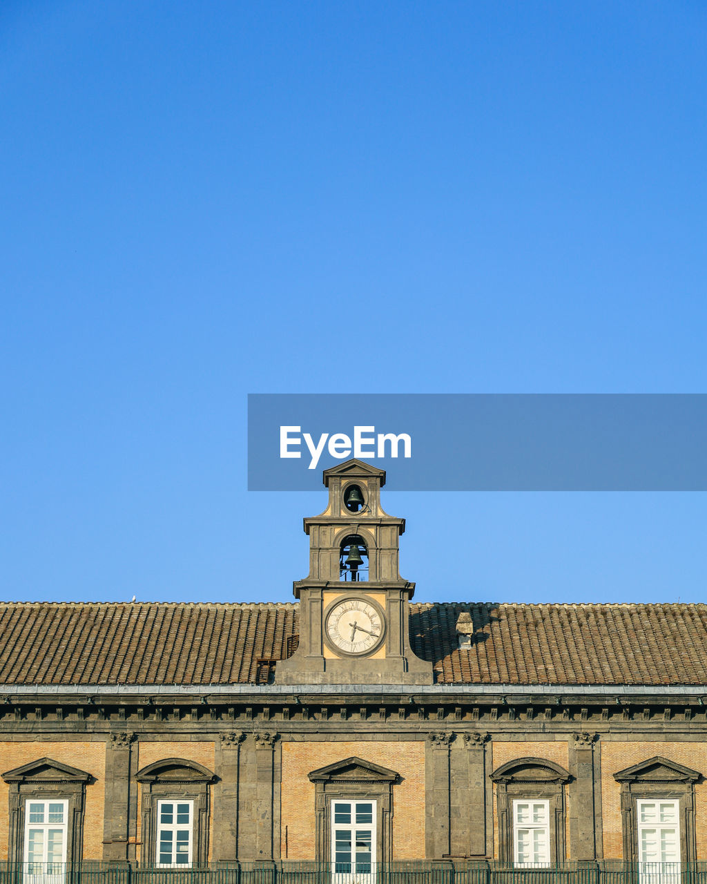 Low angle view of clock tower against clear blue sky