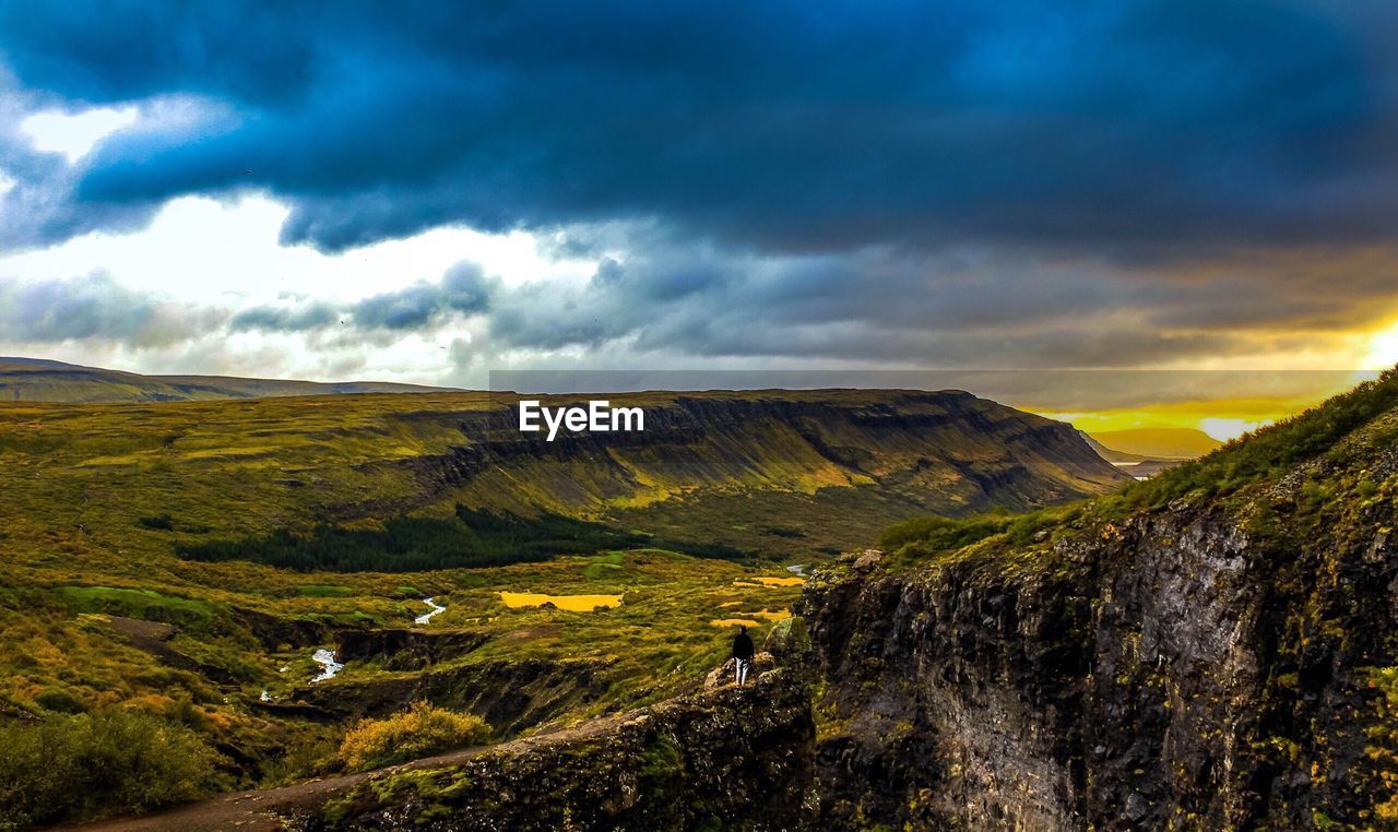 SCENIC VIEW OF MOUNTAINS AGAINST CLOUDY SKY