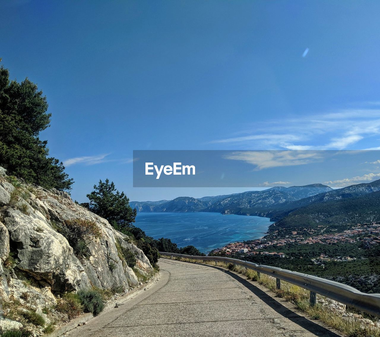 ROAD BY MOUNTAIN AGAINST BLUE SKY