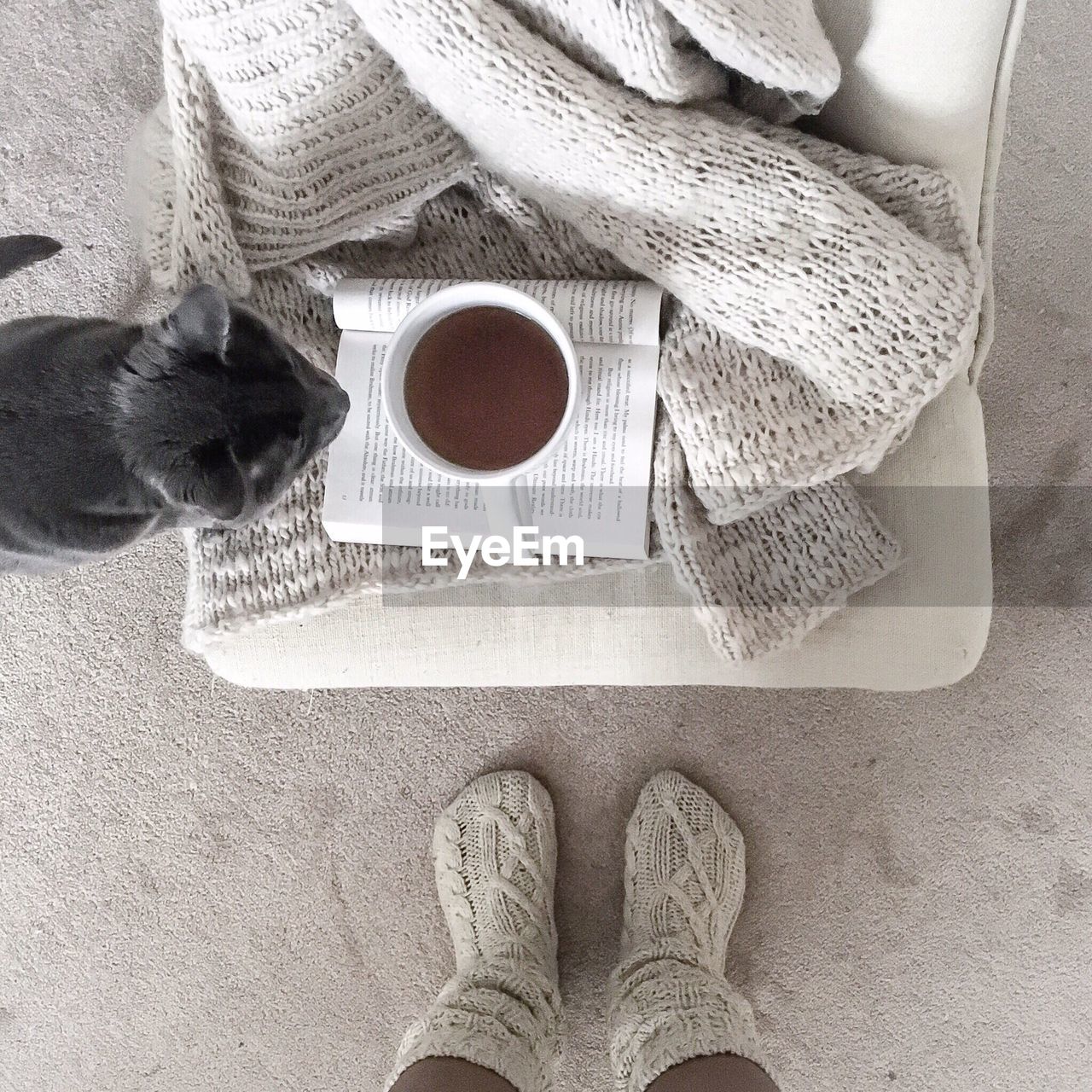 Low section of woman with coffee cup on table