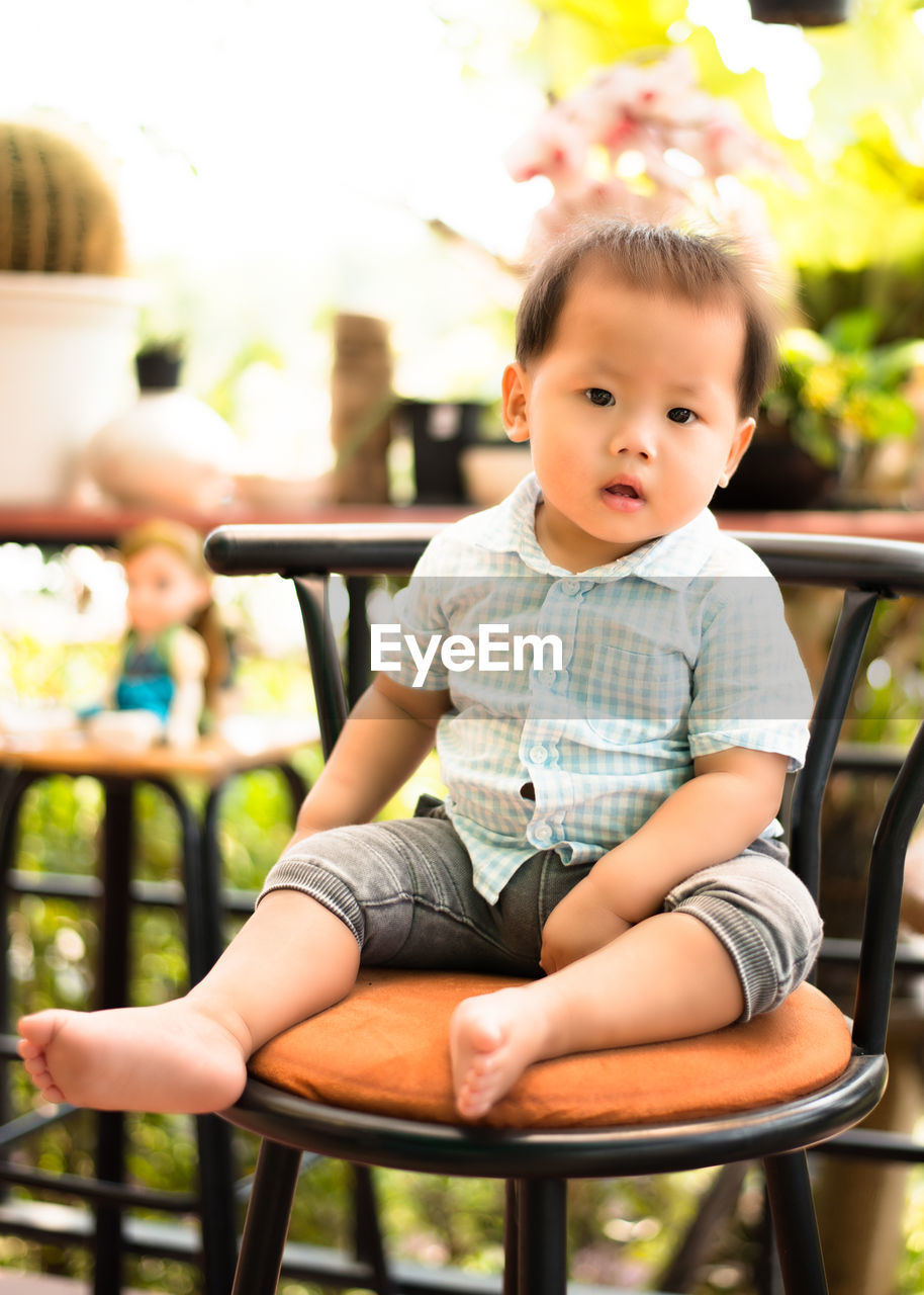Portrait of cute baby boy sitting on chair