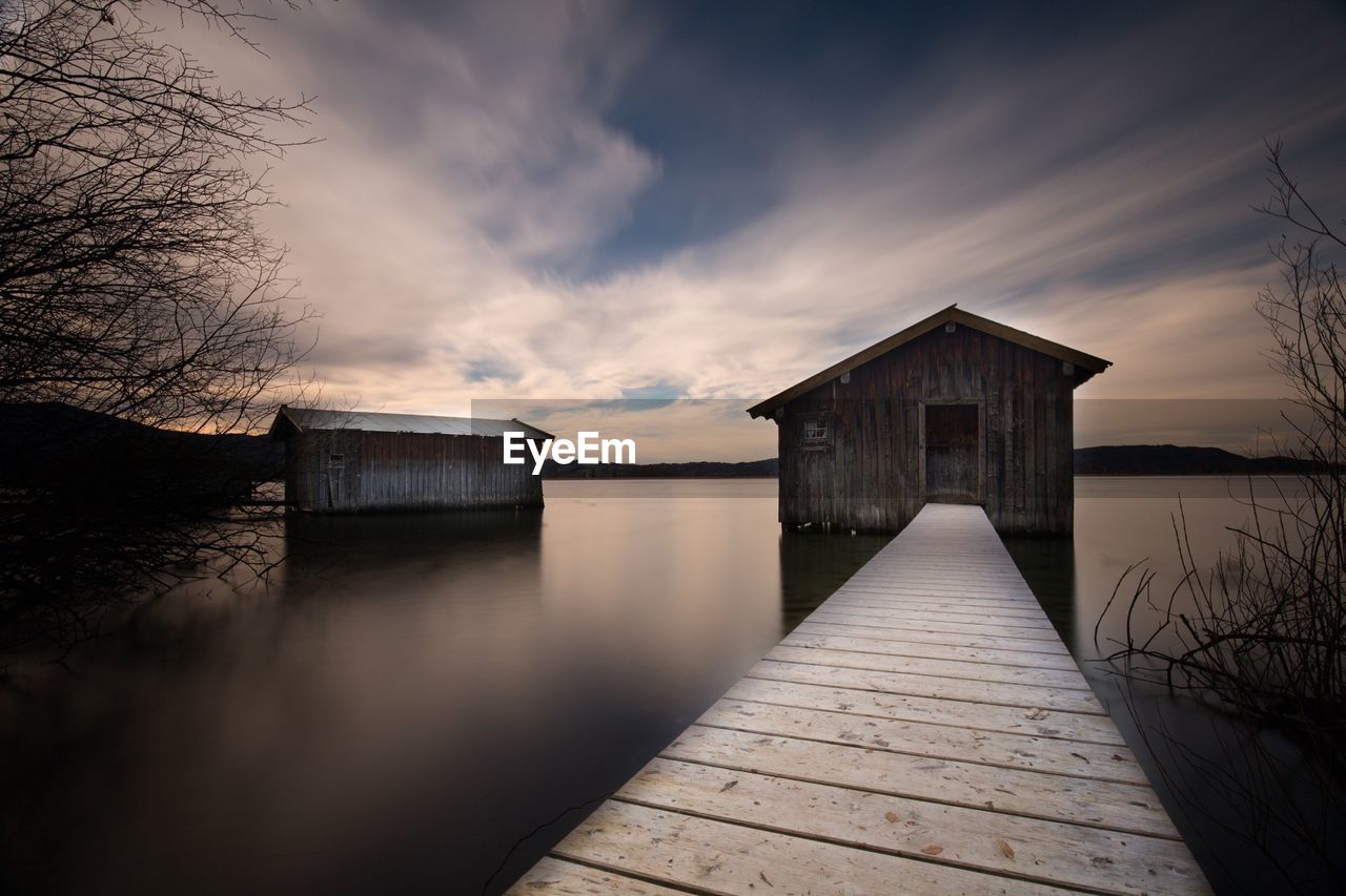 Narrow jetty at calm lake