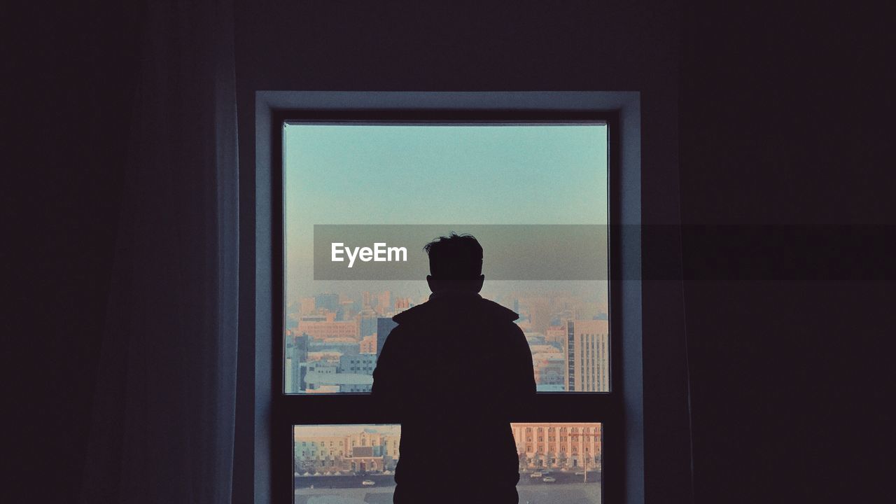 Rear view of silhouette man standing against sky