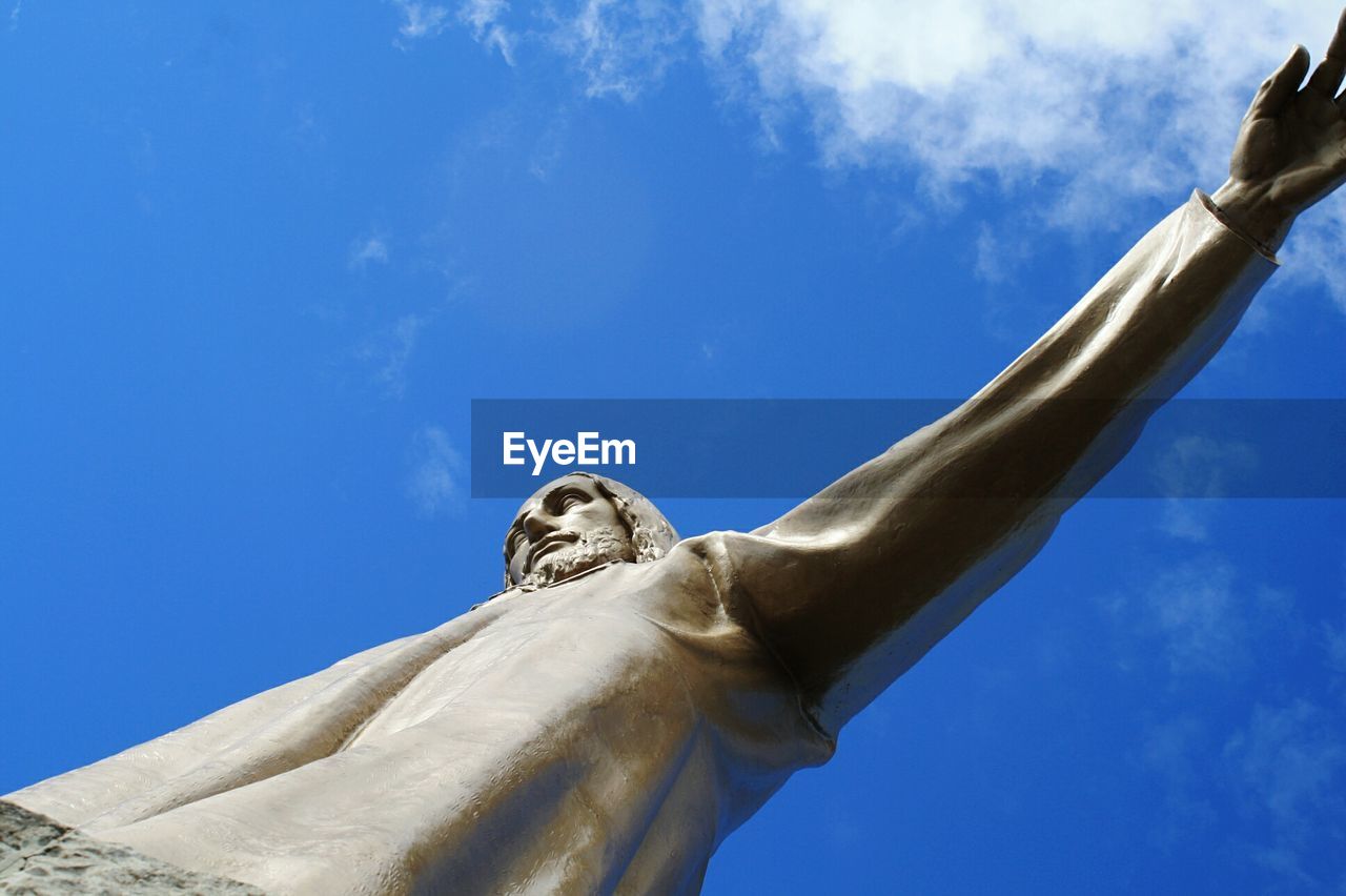 CLOSE-UP LOW ANGLE VIEW OF STATUE AGAINST BLUE SKY