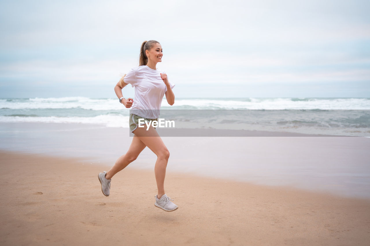 portrait of young woman standing at beach