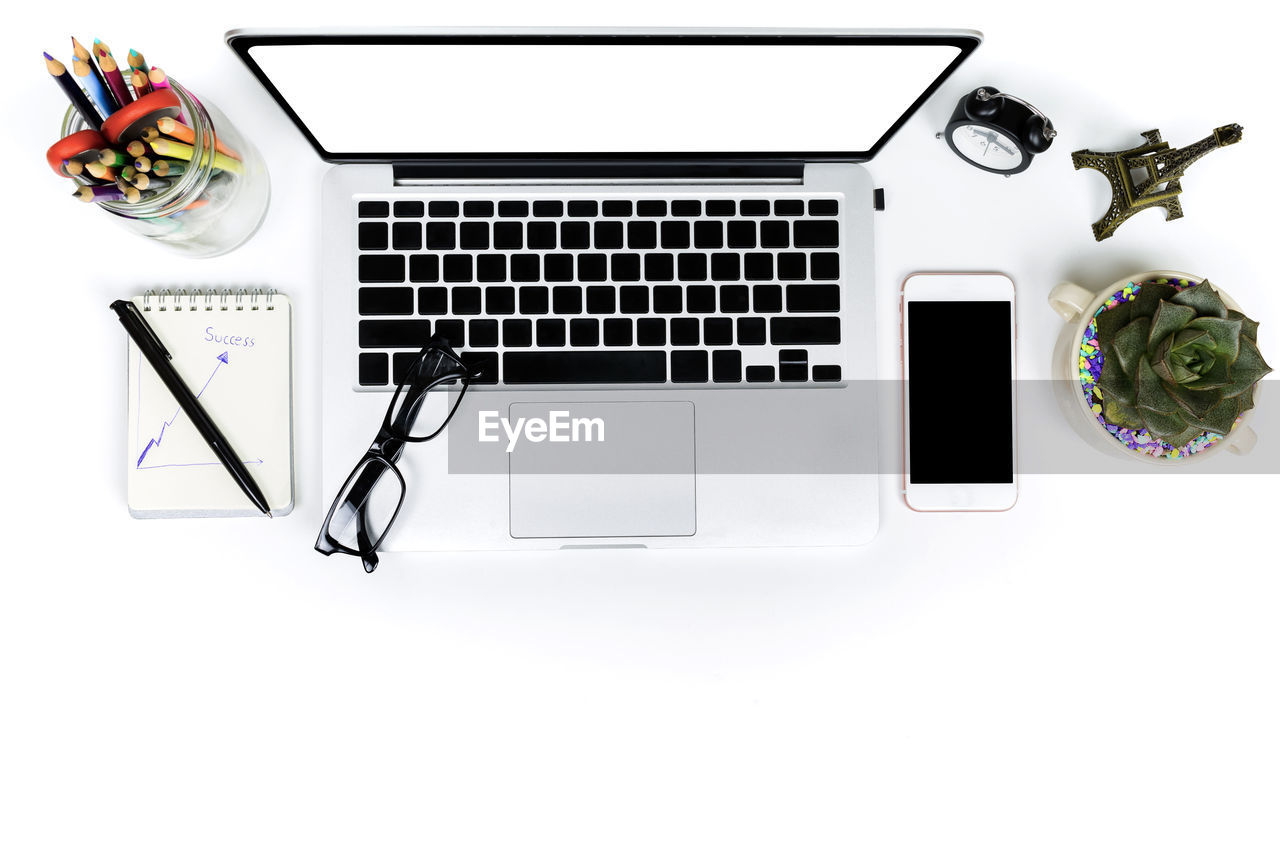 High angle view of laptop and coffee cup against white background