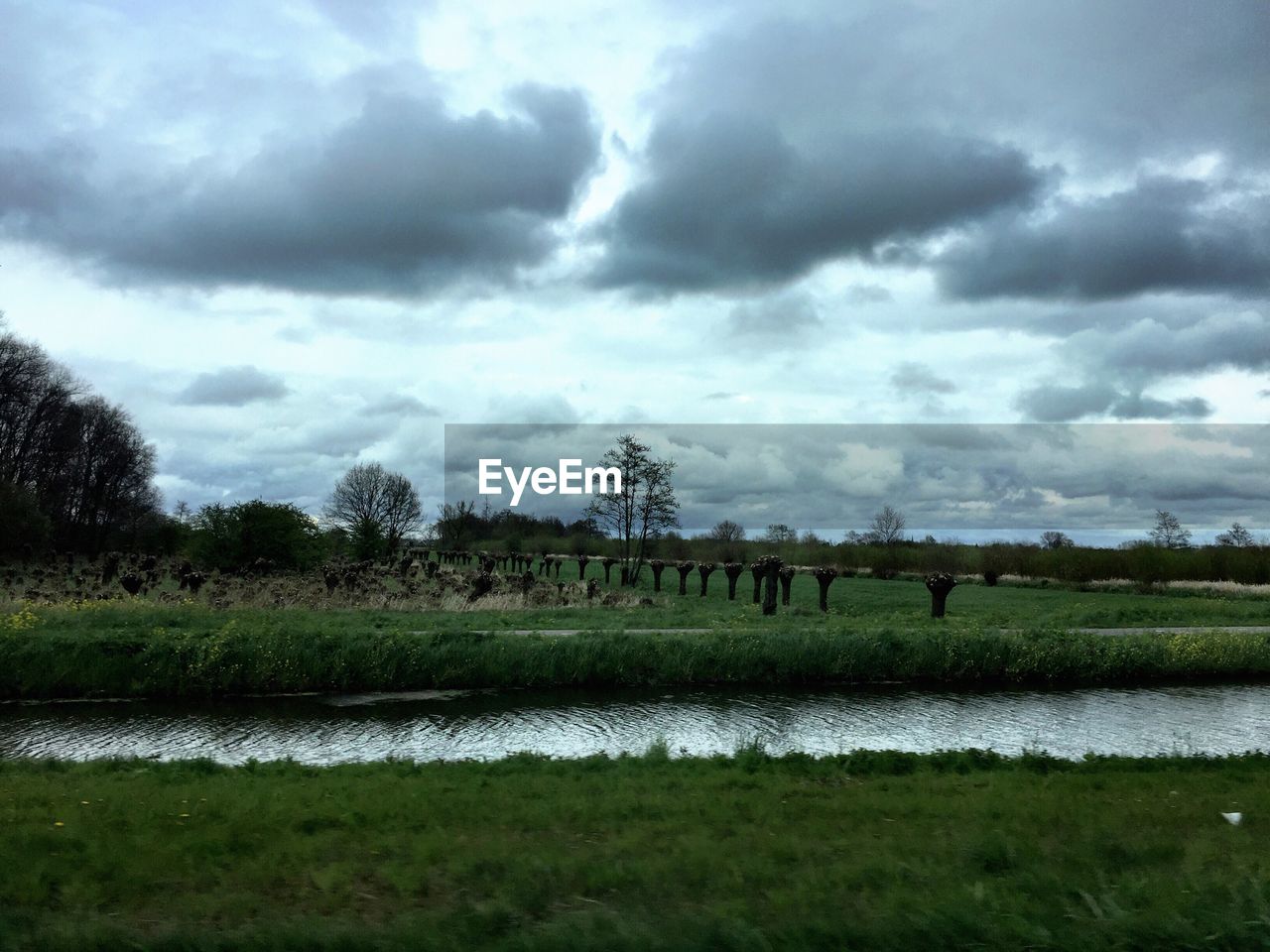 Scenic view of grassy field against cloudy sky