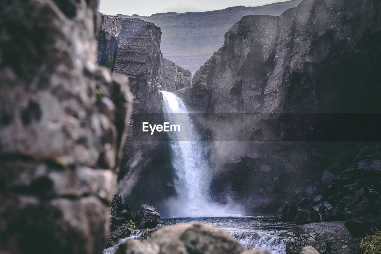 Scenic view of waterfall amidst mountains