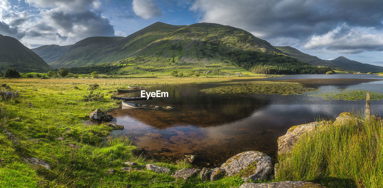 Panorama with sunken paddle boats in lough gummeenduff. beautiful black valley at sunset, ireland