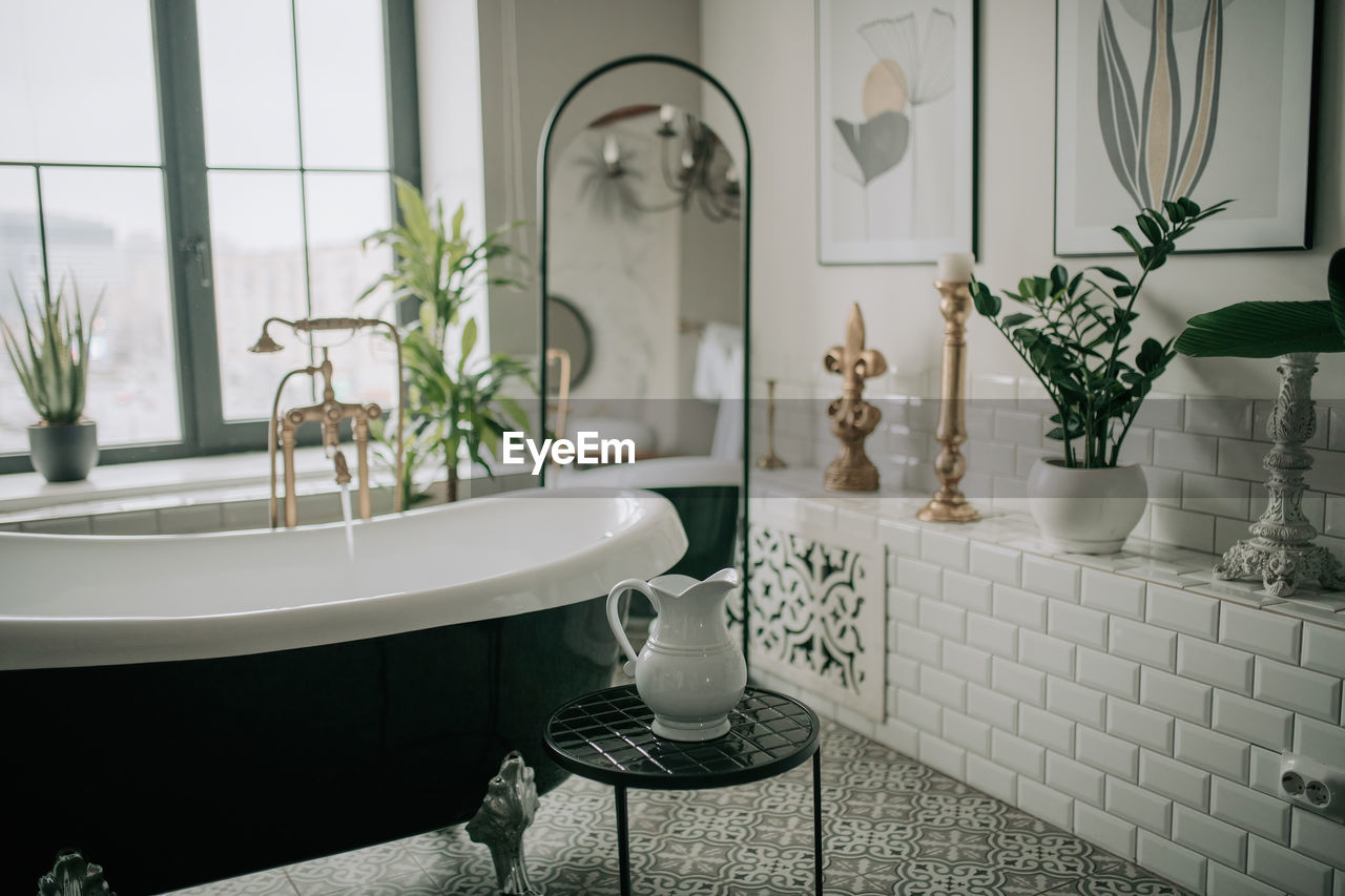 Luxury interior of big bathroom at modern african style with oval bathtub in natural lighting