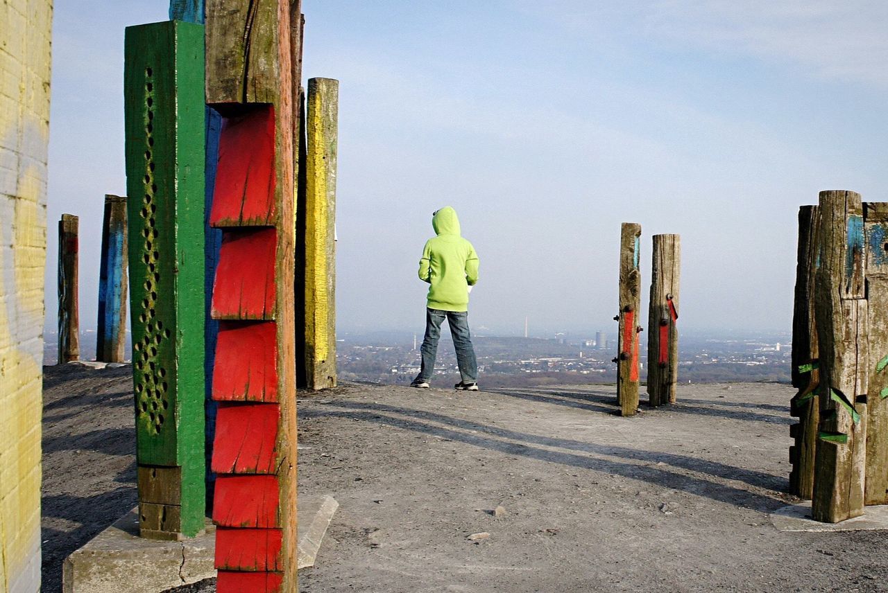 Rear view of boy wearing hooded shirt standing at observation point