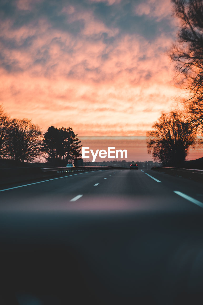 ROAD SEEN THROUGH CAR WINDSHIELD