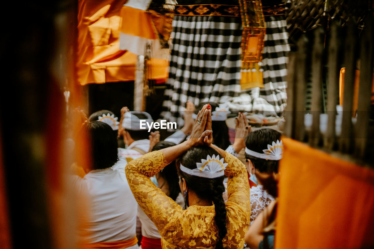 Rear view of woman praying at temple