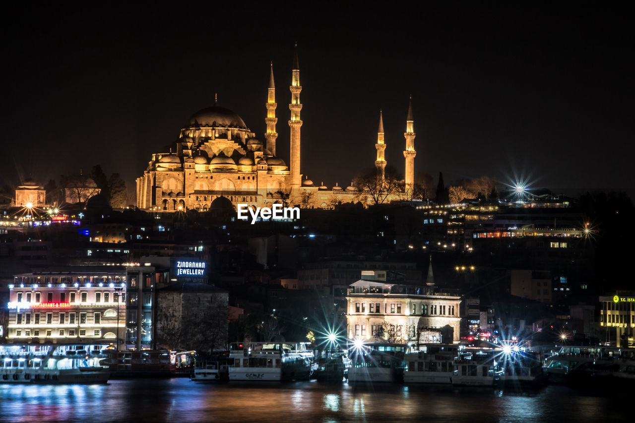 Low angle view of illuminated suleymaniye mosque and cityscape at night