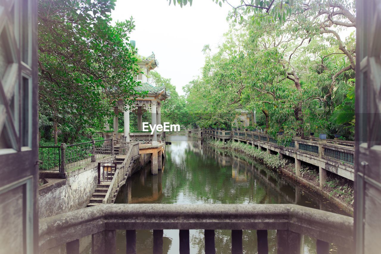 Bridge over lake against trees