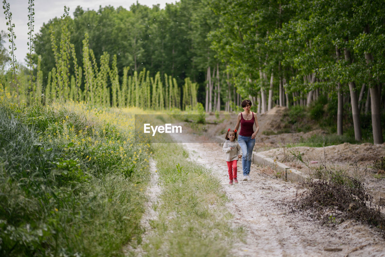 Mother and daughter walking in forest