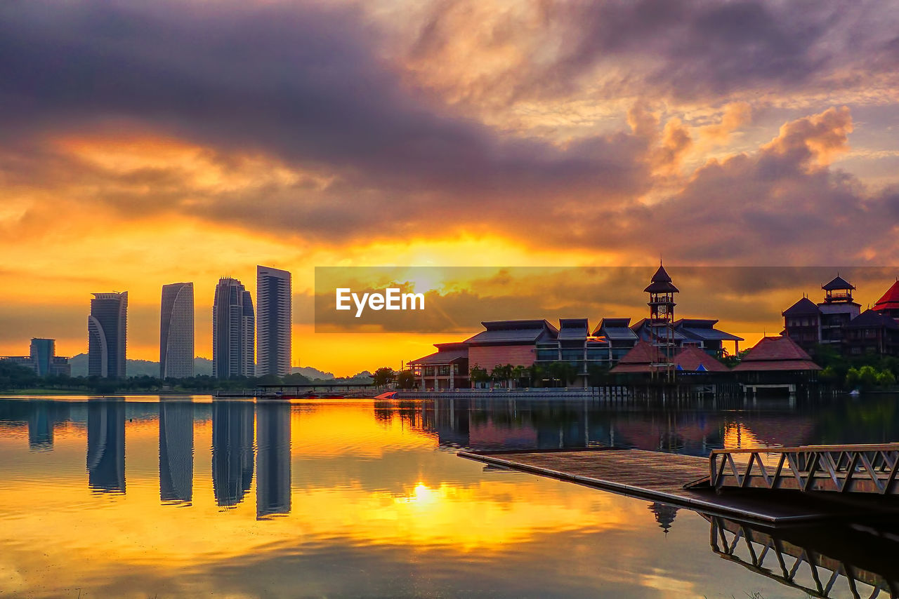 Reflection of buildings in lake at putrajaya during sunrise