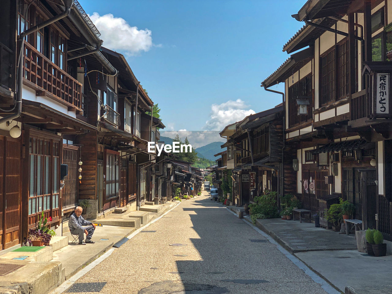 STREET AMIDST BUILDINGS AGAINST SKY IN CITY