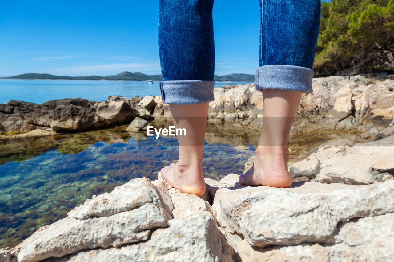 Barefoot girl on a rocky adriatic coast in croatia
