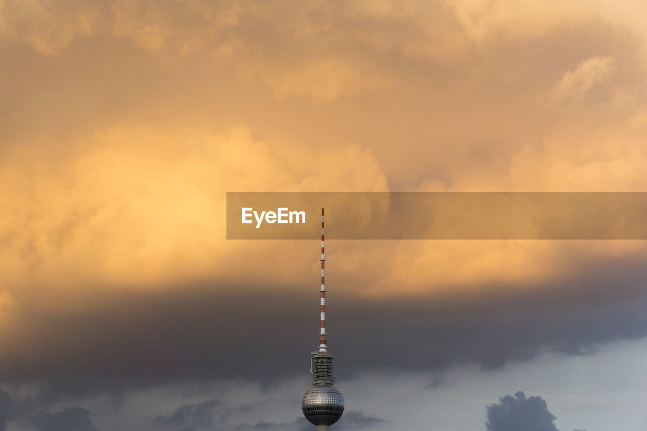 High section of fernsehturm tower against cloudy sky during sunset