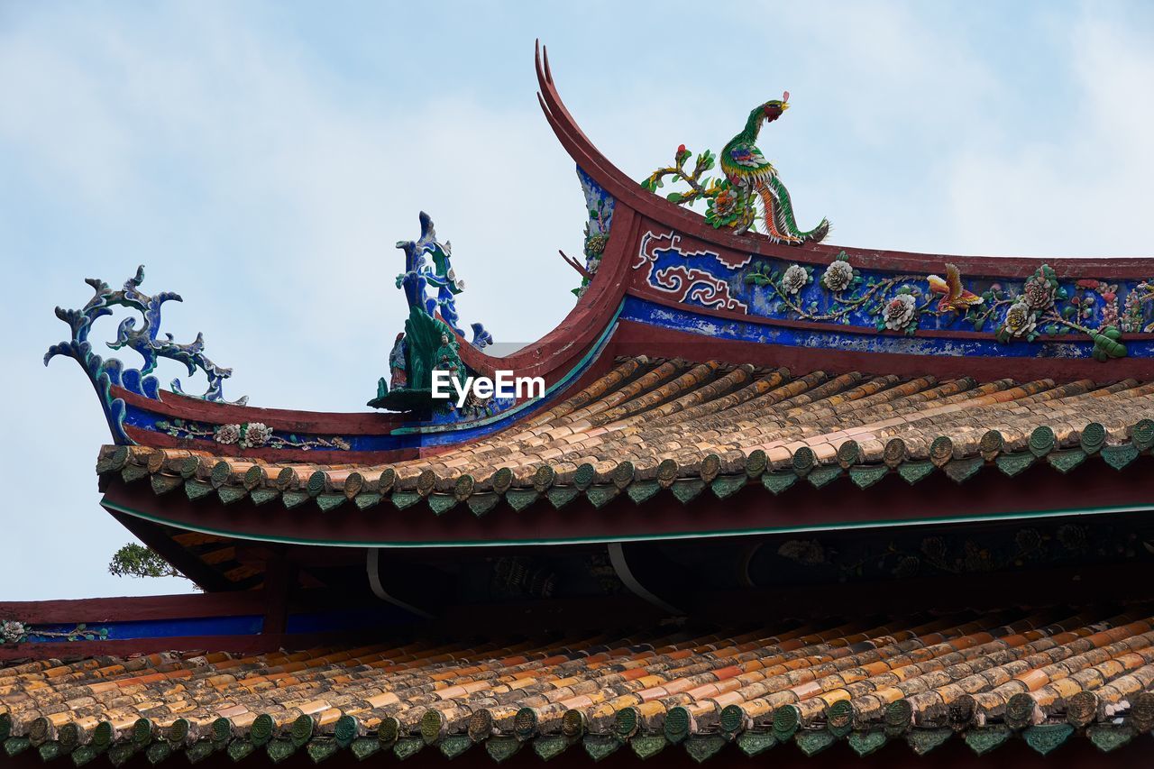 LOW ANGLE VIEW OF TEMPLE ON BUILDING ROOF AGAINST SKY