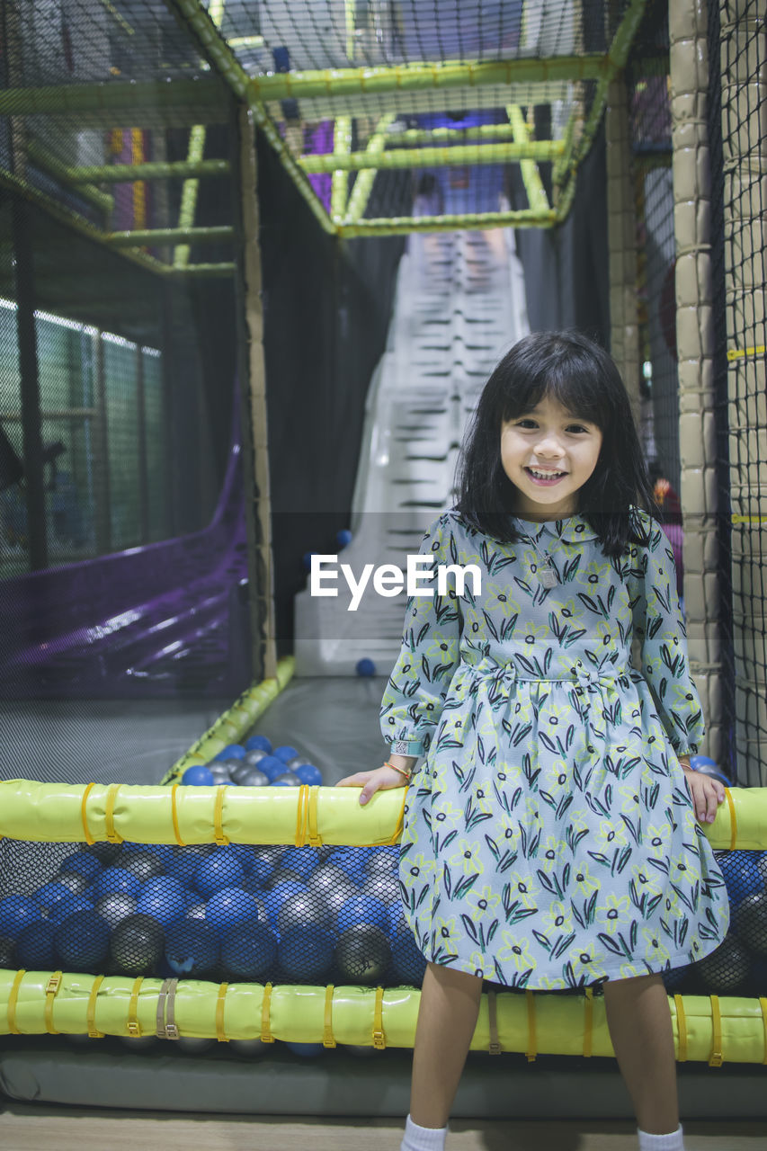 Portrait of smiling innocent girl against slide