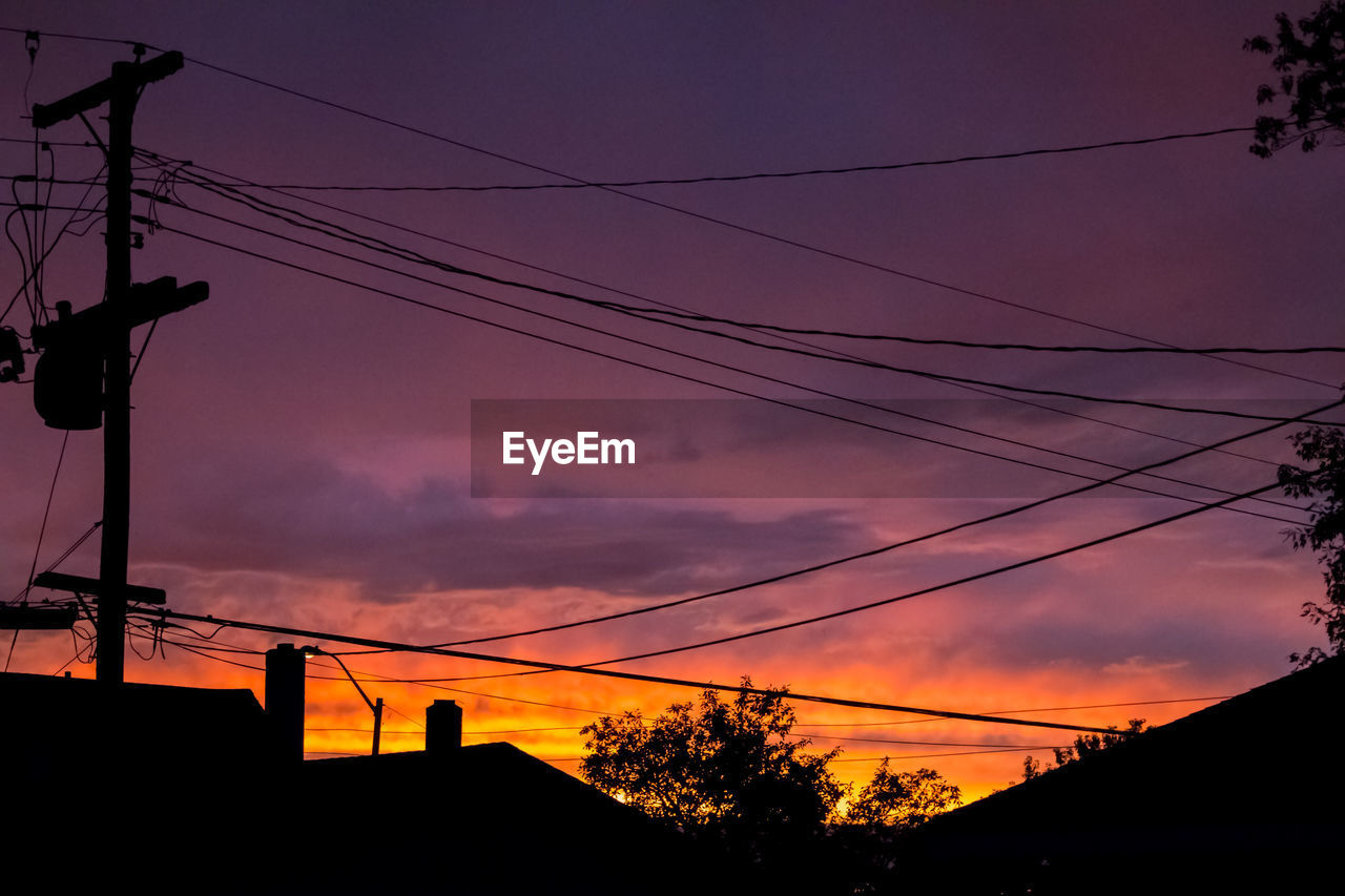 LOW ANGLE VIEW OF SILHOUETTE ELECTRICITY PYLON AGAINST SUNSET SKY