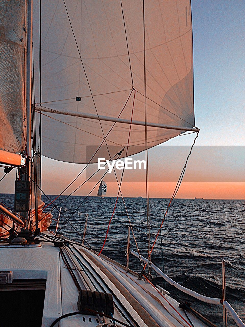 BOATS IN SEA AT SUNSET