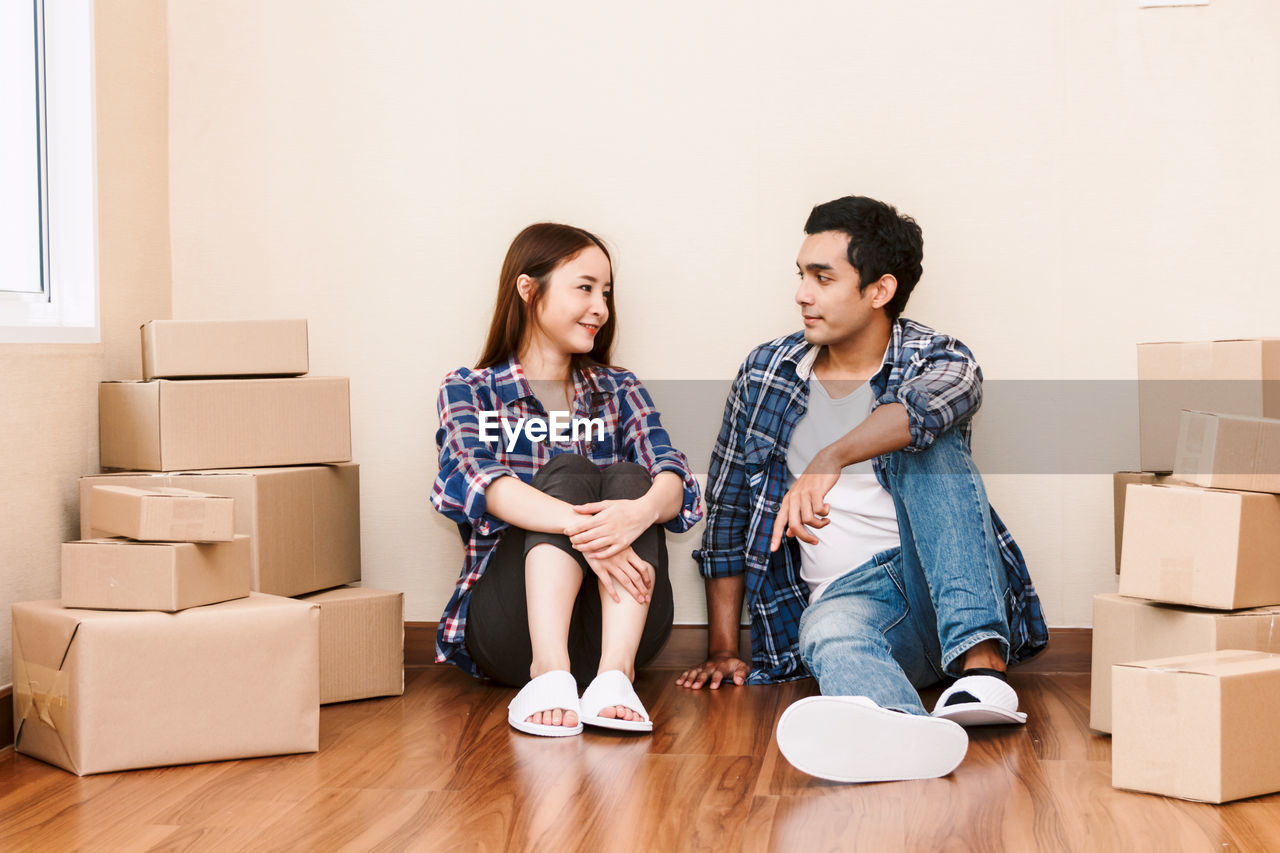 Couple sitting by wall at new home