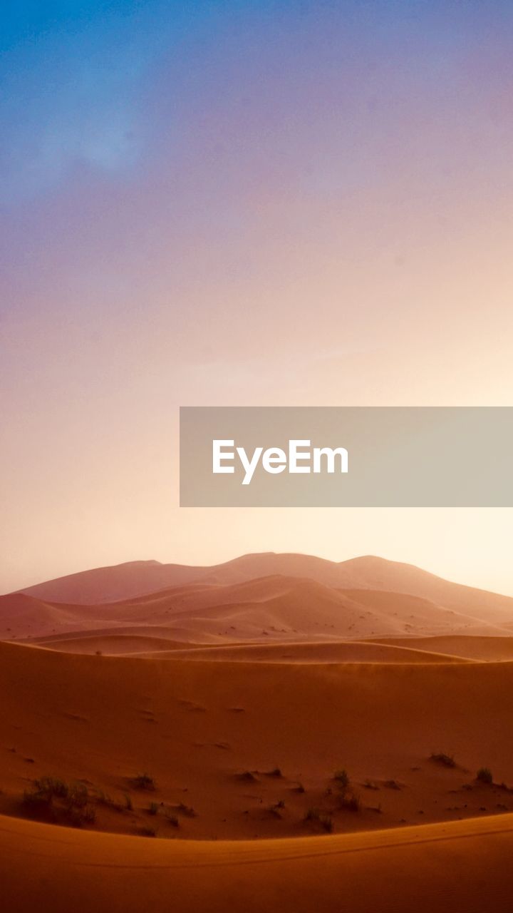 Scenic view of desert against sky during sunset