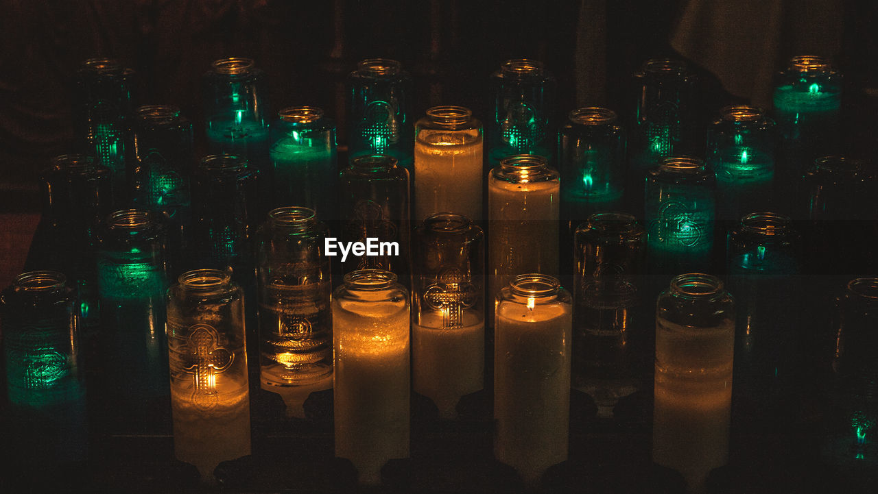 Close-up of illuminated candles in glass jars