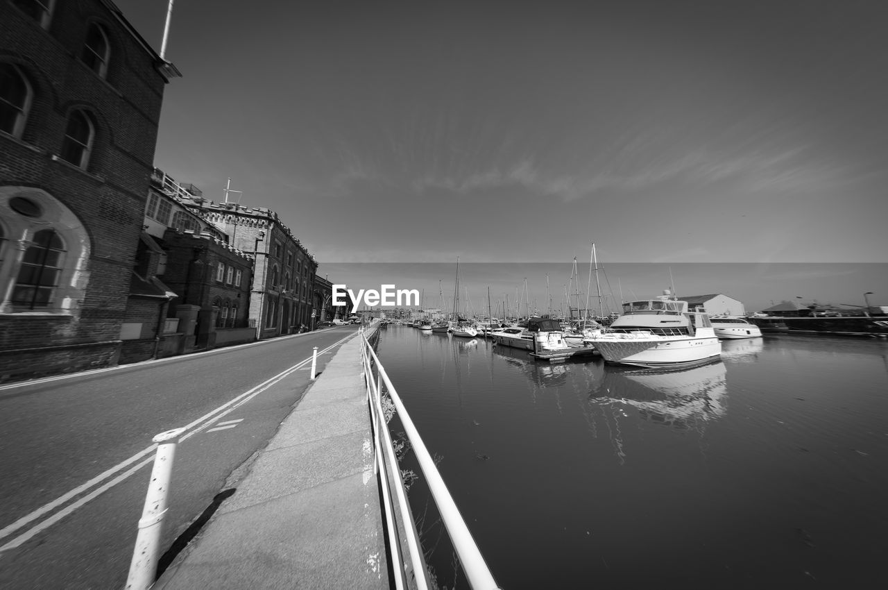 BOATS MOORED ON ROAD BY BUILDINGS IN CITY