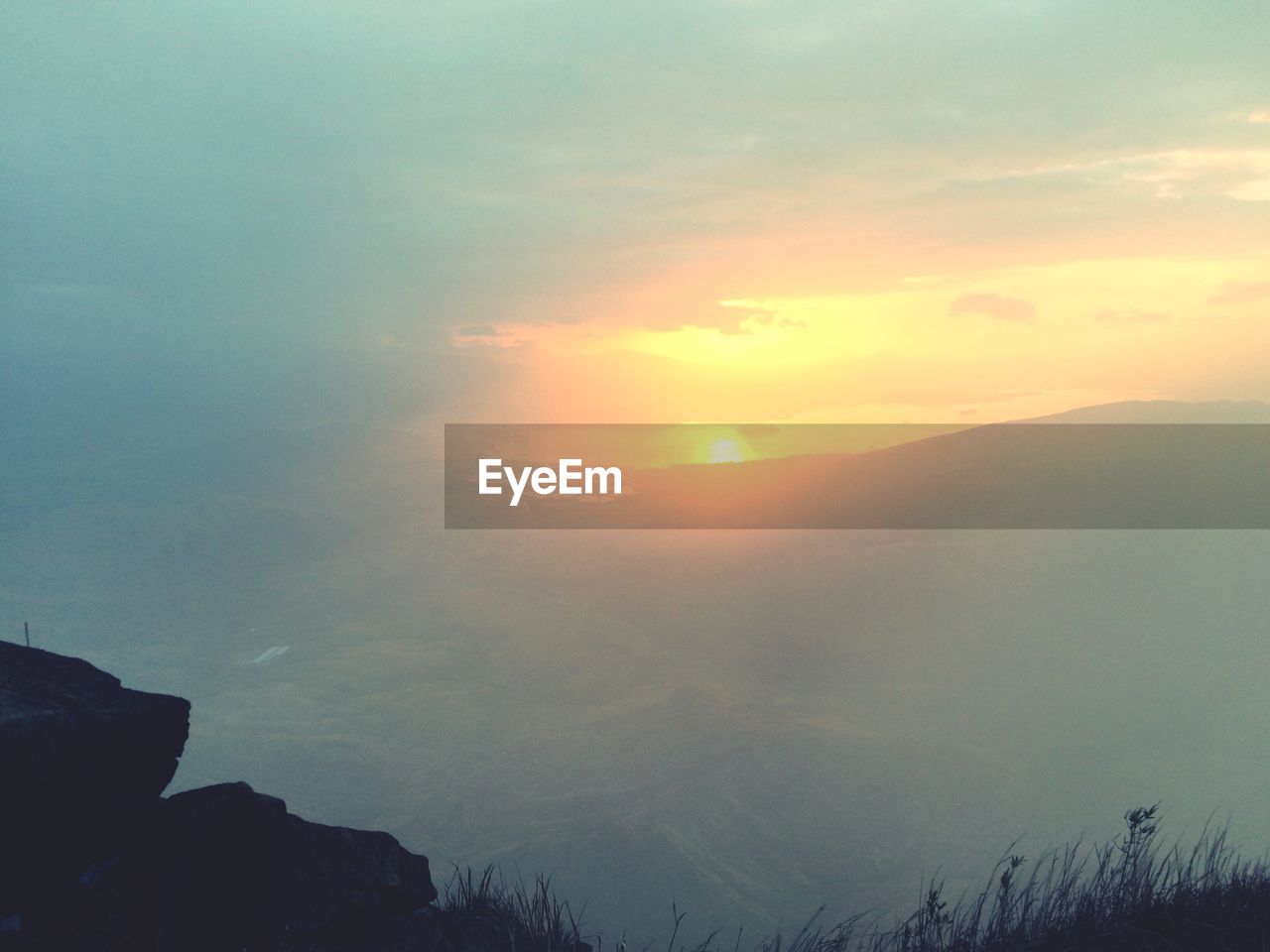 SCENIC VIEW OF SILHOUETTE MOUNTAIN AGAINST SKY AT SUNSET