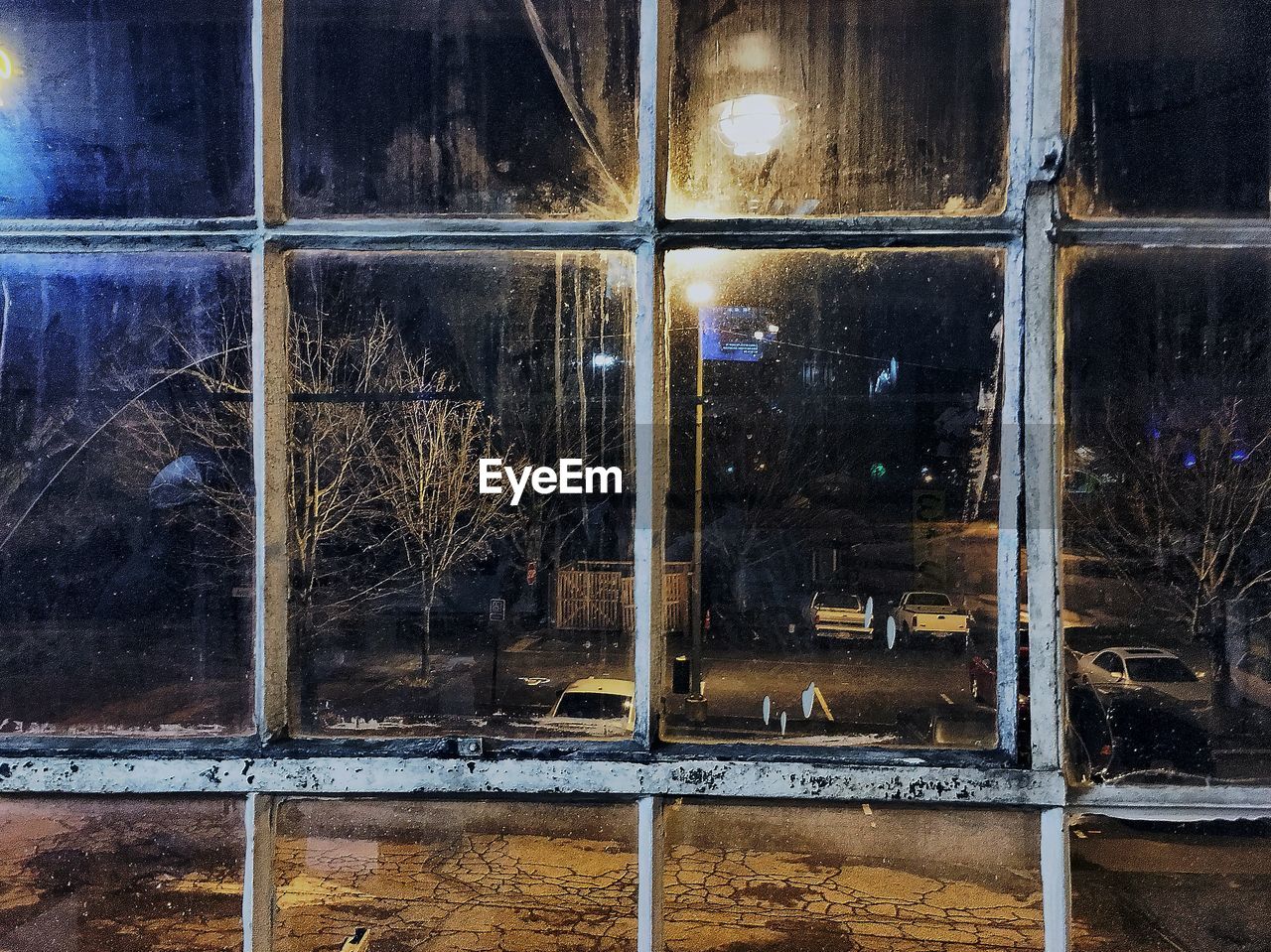 Illuminated street seen from glass window at night