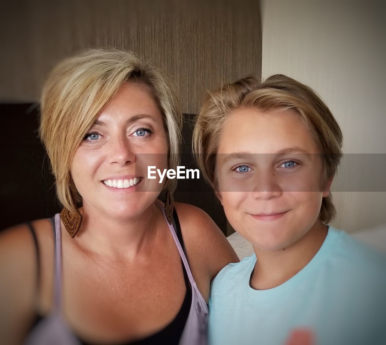 Portrait of smiling mother with son at home