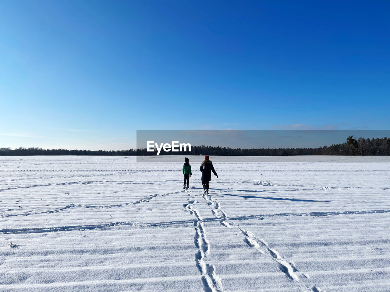 PEOPLE ON SNOW COVERED LANDSCAPE AGAINST SKY