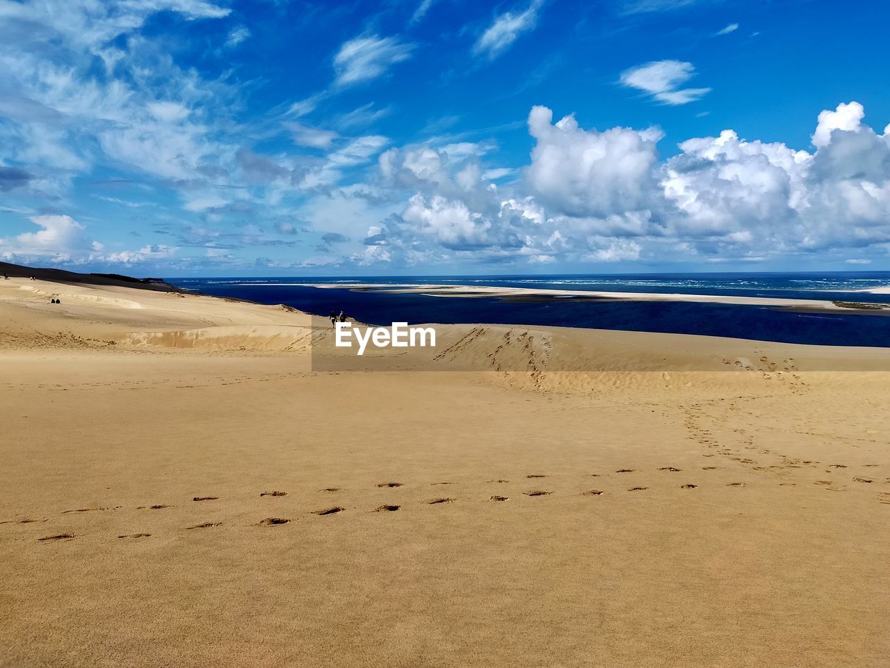 SCENIC VIEW OF SAND DUNE ON BEACH AGAINST SKY