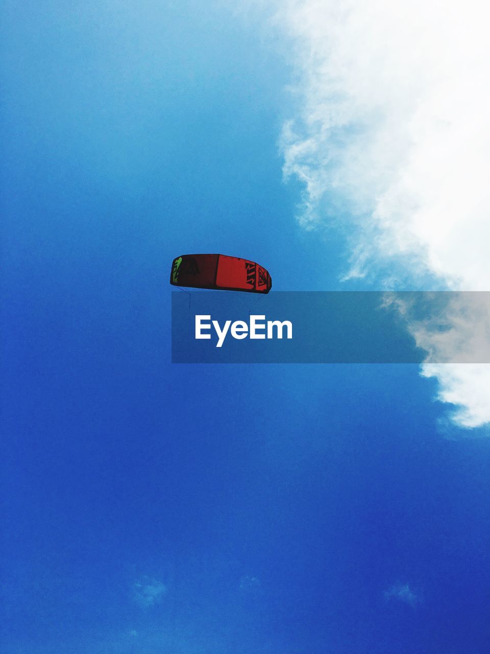 Low angle view of paragliding against blue sky