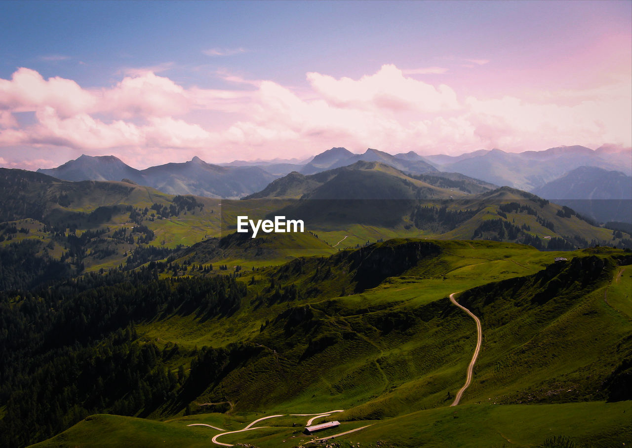 Scenic view of green landscape against cloudy sky