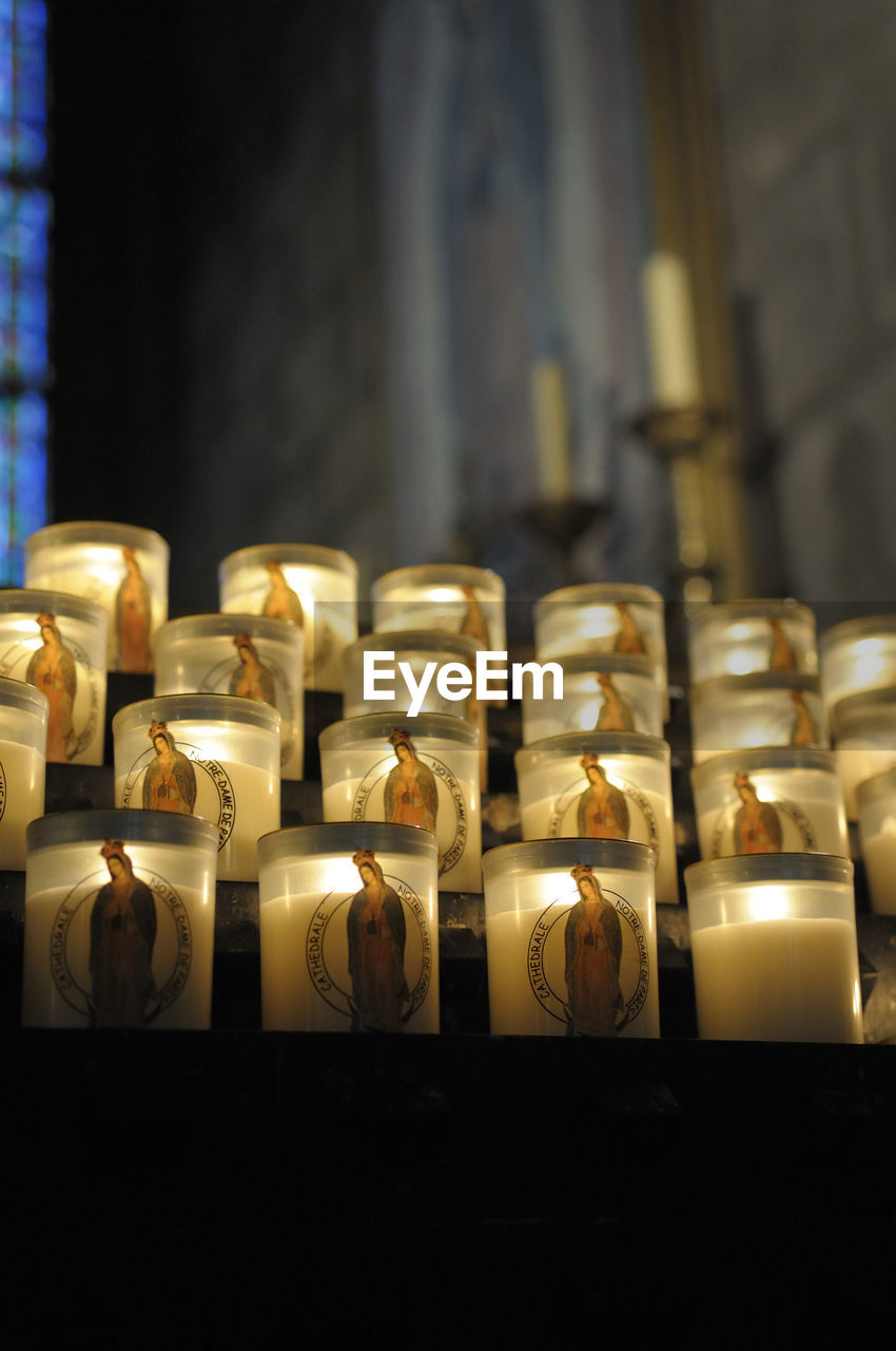 CLOSE-UP OF ILLUMINATED CANDLES IN TEMPLE