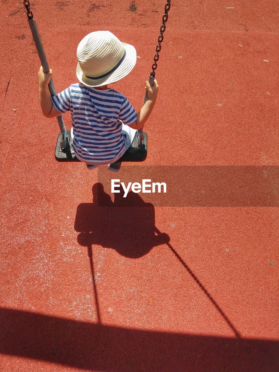 High angle view of boy sitting on swing