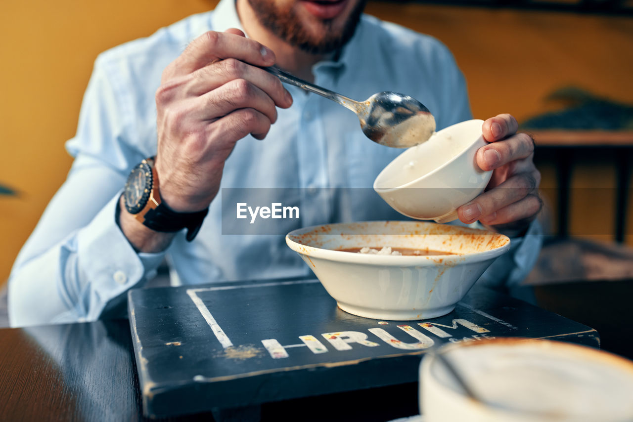 Midsection of man preparing food in kitchen