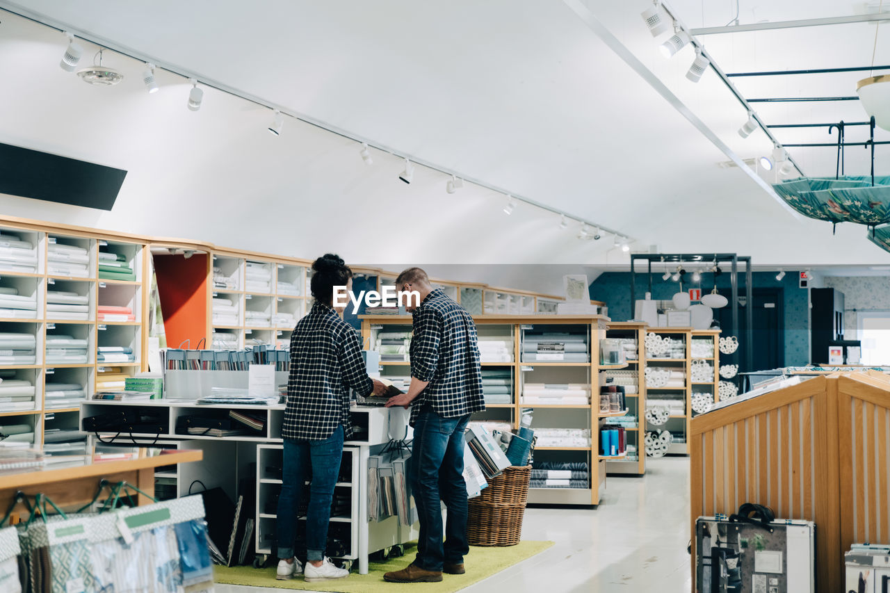 Rear view of male and female employees working in store